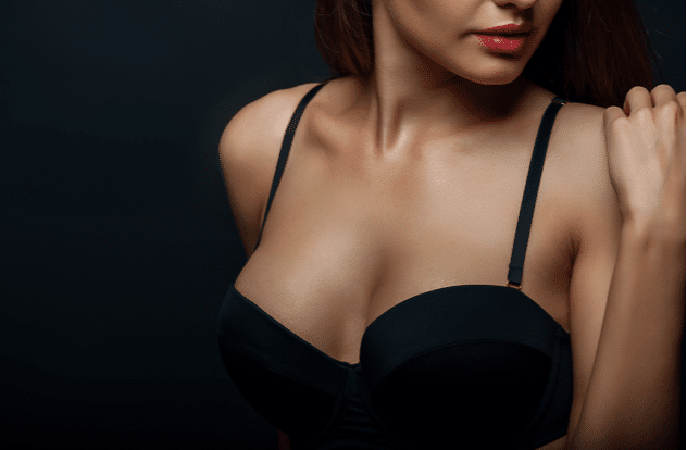 Close up of breast of attractive woman presenting her black bra.