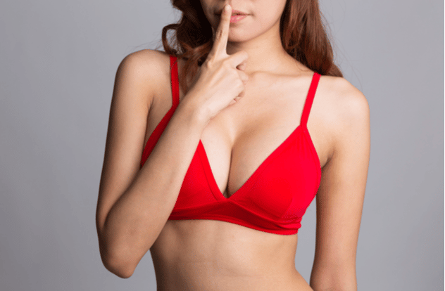 young sexy woman in red bra gesturing hush