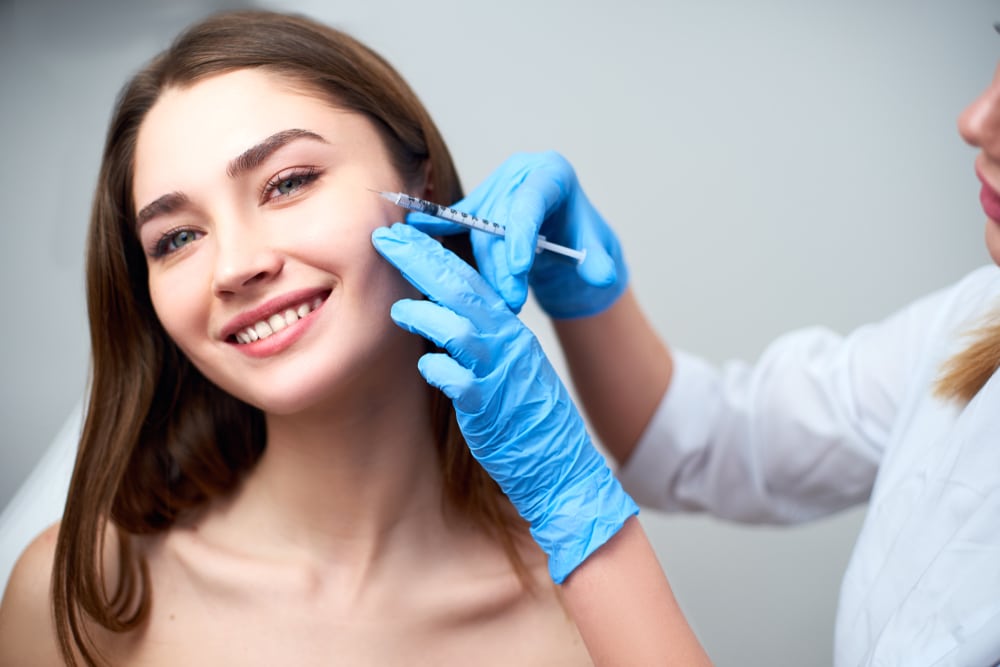 Smiling woman getting injectable dermal fillers in her face in Savannah, GA