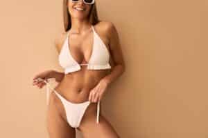 Woman in bikini after tummy tuck and breast augmentation in Savannah, GA